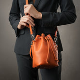 Secchiello piccolo Bianca, borsa a spalla o a mano da donna in pelle martellata arancio, realizzata e venduta da Pianigiani Bags